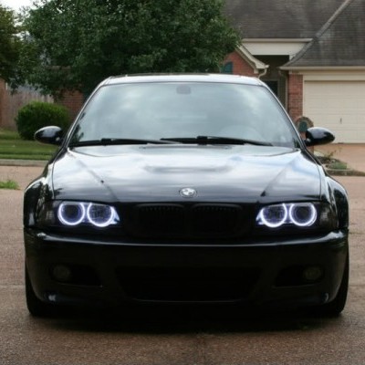 Carro preto com faróis LED em frente a garagem residencial