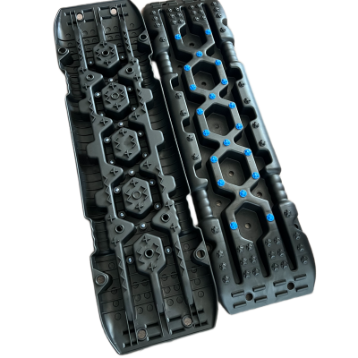 Placas de tracção negras com parafusos azuis em fundo branco