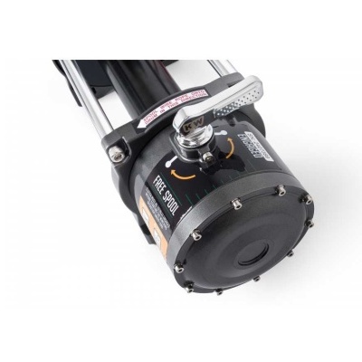 Carretel de pesca preto com manivela prateada e etiquetas visíveis.