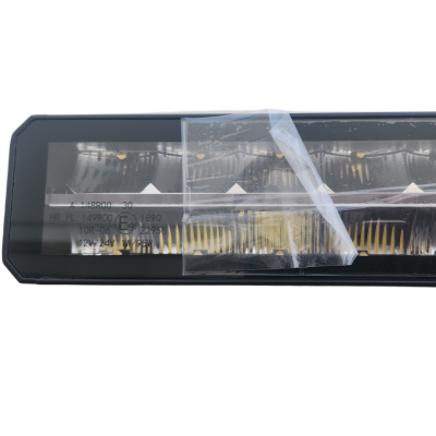 Luz traseira de automóvel preta retangular com película plástica e texto impresso.