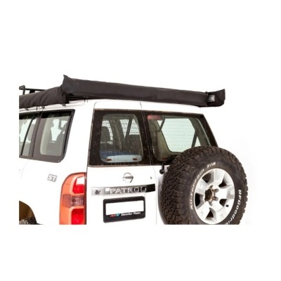 Veículo Nissan Patrol branco com pneu sobressalente e tenda preta no tejadilho