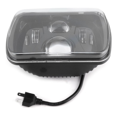 Farol retangular com lente transparente e cabo elétrico preto