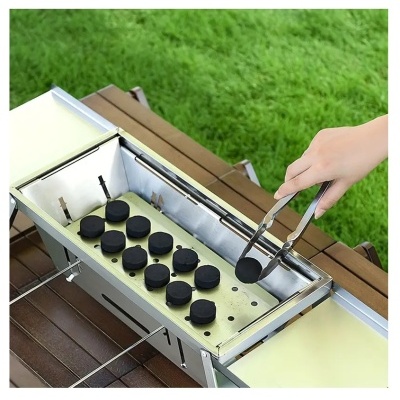 Grelhador metálico com placas pretas e mão usando pinça