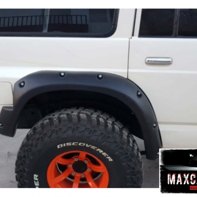 Guarda-lamas preto em veículo branco com pneus robustos e jantes laranja