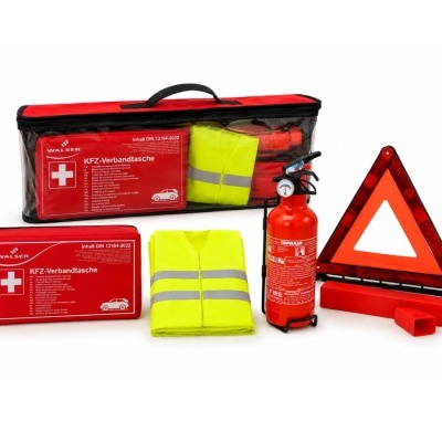 Kit de segurança automóvel com bolsa vermelha, colete amarelo, extintor e triângulo de sinalização.
