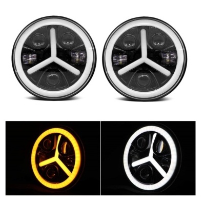 Faróis circulares para automóvel com anéis de luz LED âmbar e branco e barras brancas em Y no centro.