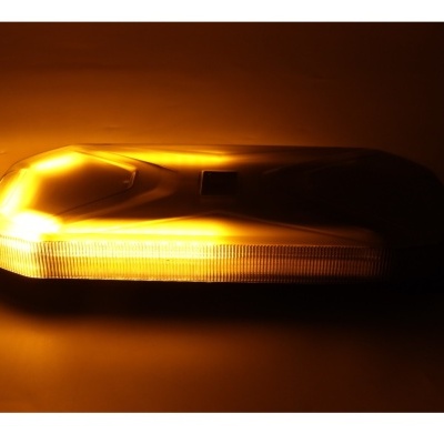Luz amarela com cobertura translúcida iluminada numa superfície escura