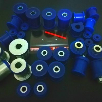 Vários buchas e espaçadores de poliuretano azuis e brancos sobre superfície escura