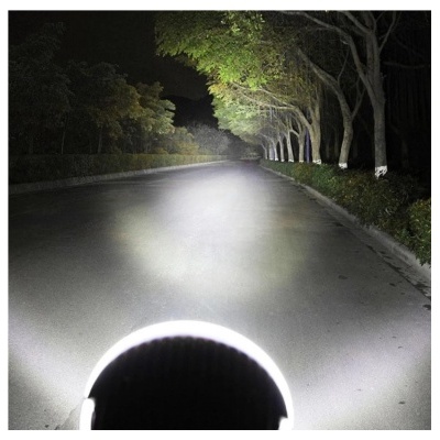 Estrada iluminada por luz forte à noite com árvores nas laterais