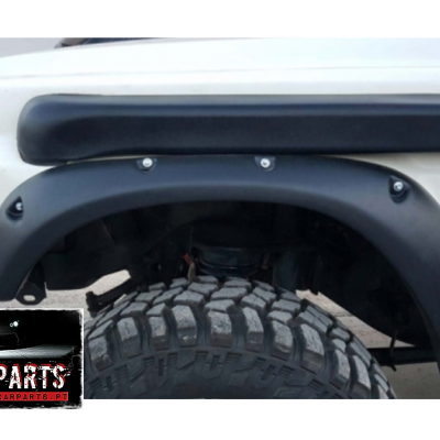 parte lateral dianteira de veículo branco com para-lamas pretos e pneus grandes