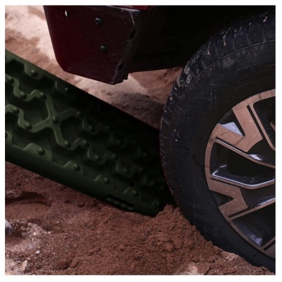 Roda de carro presa em areia com placa antiderrapante verde escura