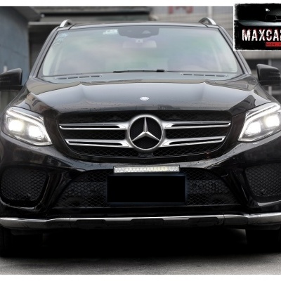 SUV preto Mercedes-Benz visto de frente com faróis acesos e grelha cromada