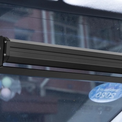 Dispositivo preto fixado no para-brisas de um carro com logotipo MAXCARPARTS