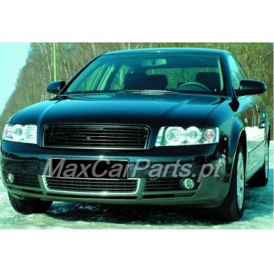 Carro preto sedan visto de frente com faróis duplos e neve ao redor