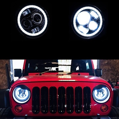 Faróis dianteiros redondos iluminados num Jeep vermelho