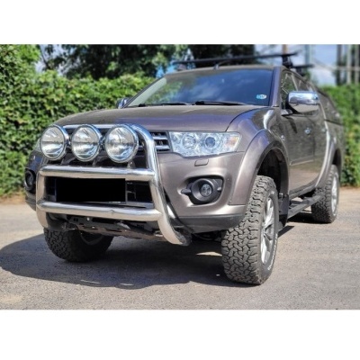 Veículo utilitário desportivo cinza metálico com barra frontal e faróis extras