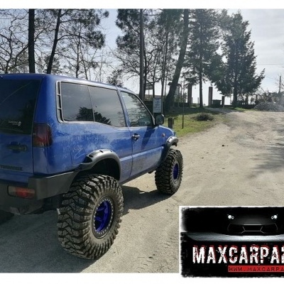 Veículo todo-o-terreno azul com pneus grandes e logo Maxcarparts.