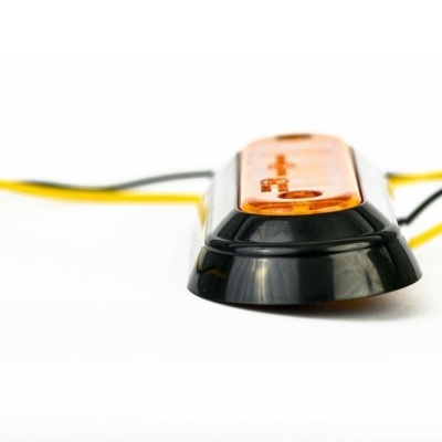 Luz traseira de bicicleta preta com tampa laranja sobre fundo branco