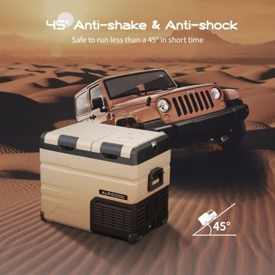 Caixa térmica bege e preta na areia com veículo todoterreno castanho ao fundo