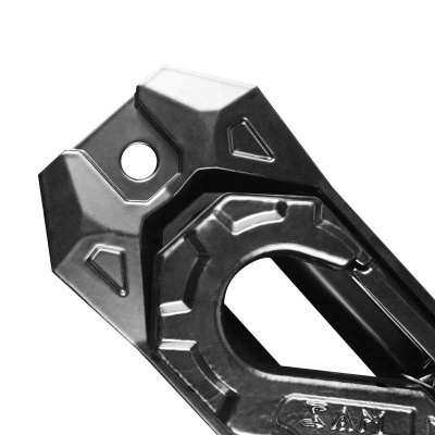 Peça metálica preta com relevo geométrico e orifício circular