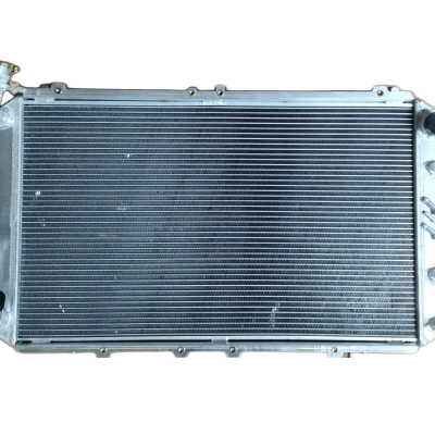 Radiador automóvel em alumínio com aletas horizontais e tampa metálica.