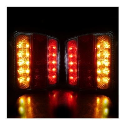 Par de luzes traseiras vermelhas e amarelas de automóvel acesas em ambiente escuro