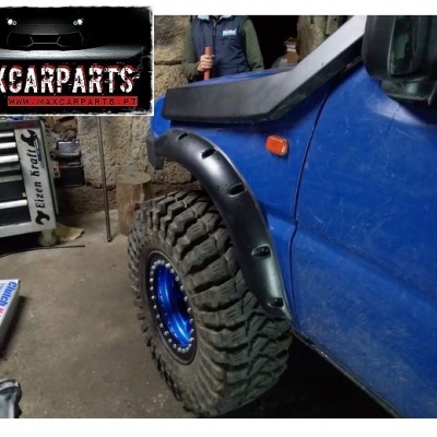 Veículo azul com pneu todo-o-terreno e para-lamas pretos em oficina