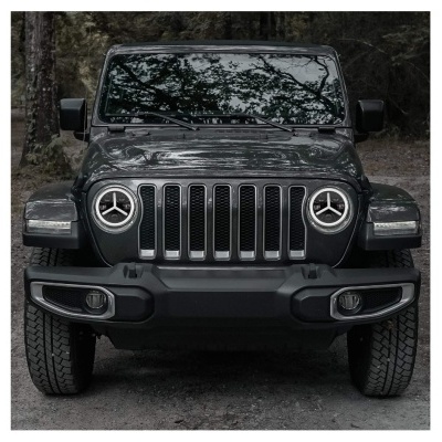 Frontal de veículo todo-o-terreno preto com faróis redondos e grelha com sete ranhuras.