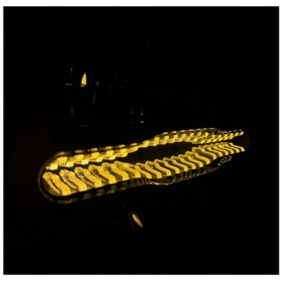 Ténis luminoso preto com padrão amarelo ziguezague em fundo escuro