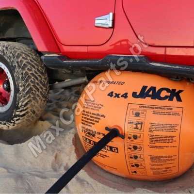 Elevador inflável laranja 4x4 JACK ao lado da roda traseira vermelha de um veículo todo-o-terreno