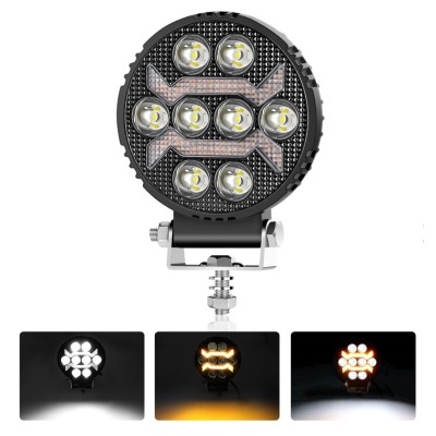 Farol redondo preto com LEDs e setas de luz âmbar em suporte metálico.