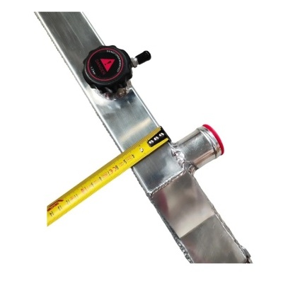 Radiador metálico prateado com válvula preta e vermelha e fita métrica amarela