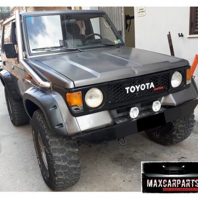 Veículo todo-o-terreno Toyota Land Cruiser cinza metálico com faróis redondos e pneus off-road