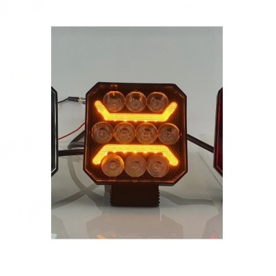 Luz automotiva quadrada com LEDs amarelos e lentes transparentes.