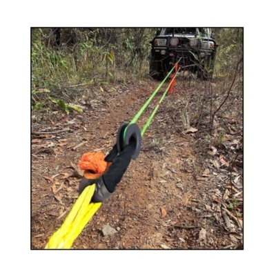 Cabo de reboque amarelo e verde ligado a veículo todo-o-terreno preto em trilho de terra