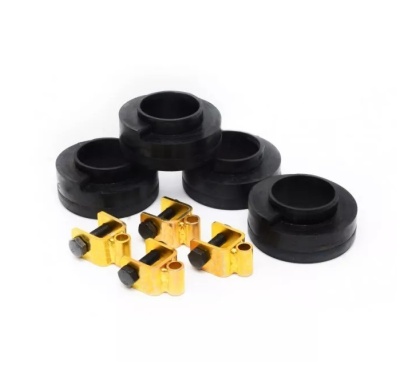 Conjunto de calços pretos circulares em borracha e presilhas douradas metálicas sobre fundo branco.