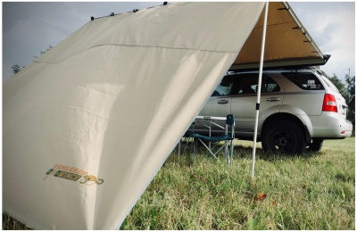 Tenda de campismo bege ao lado de carro SUV branco na relva com cadeira de campismo azul