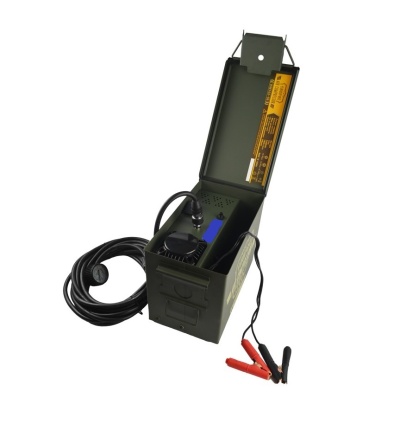 Dispositivo eletrônico preto numa caixa metálica verde com cabos e garras vermelhas e pretas