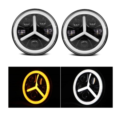 Faróis circulares para automóvel com anéis de luz LED âmbar e branco e barras brancas em Y no centro.