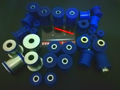 Vários buchas e espaçadores de poliuretano azuis e brancos sobre superfície escura