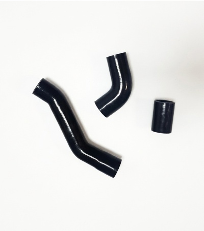 Três tubos pretos brilhantes de silicone em superfície branca
