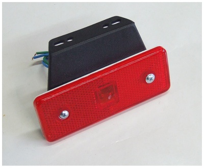 Refletor vermelho retangular com suporte preto e fios elétricos.