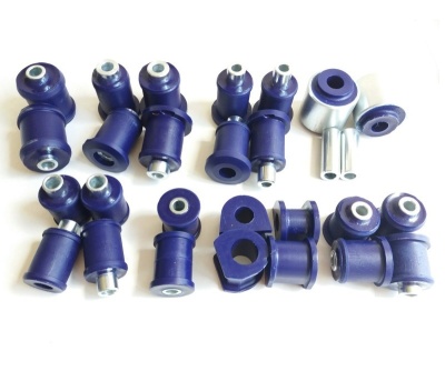 Conjunto de buchas automóvel em borracha azul e metal prateado sobre fundo branco