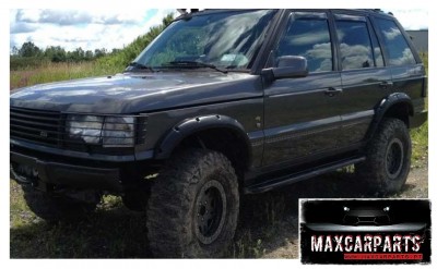 SUV preto todo-o-terreno com pneus grandes em área campestre