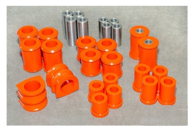 Conjunto de buchas laranja e espaçadores metálicos sobre fundo cinzento