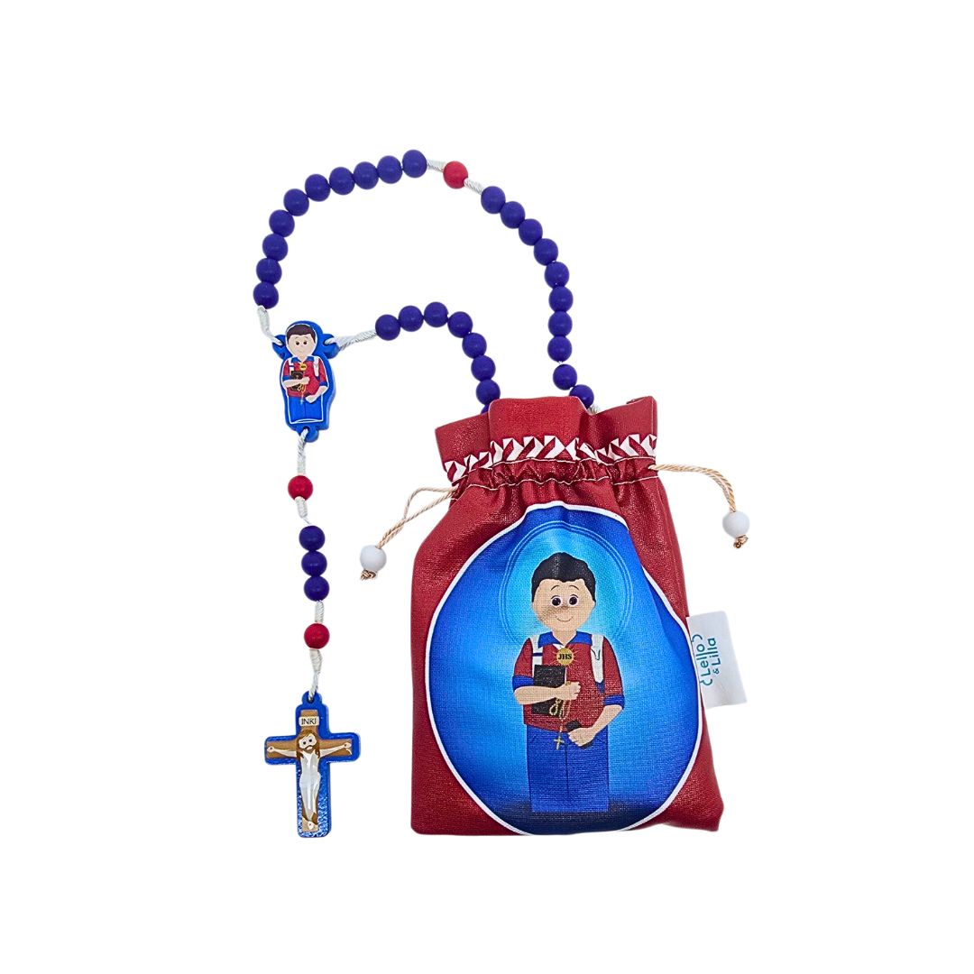 Terço com crucifixo, contas azuis e vermelhas, e bolsa vermelha com ilustração de menino segurando Bíblia