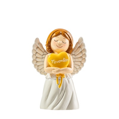Estatueta de anjo a segurar coração amarelo com a palavra November