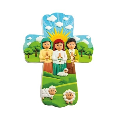 Cruz decorativa pintada com três figuras a rezar e ovelhas num campo verde.