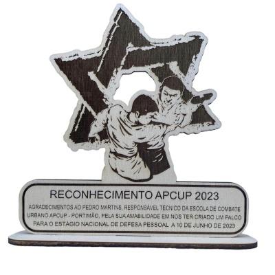 Estatueta reconhecimento APCUP 2023 com star e praticantes de defesa pessoal