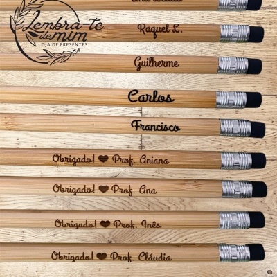 Lápis de madeira personalizados com nomes e mensagens de agradecimento para professores sobre uma mesa de madeira clara.